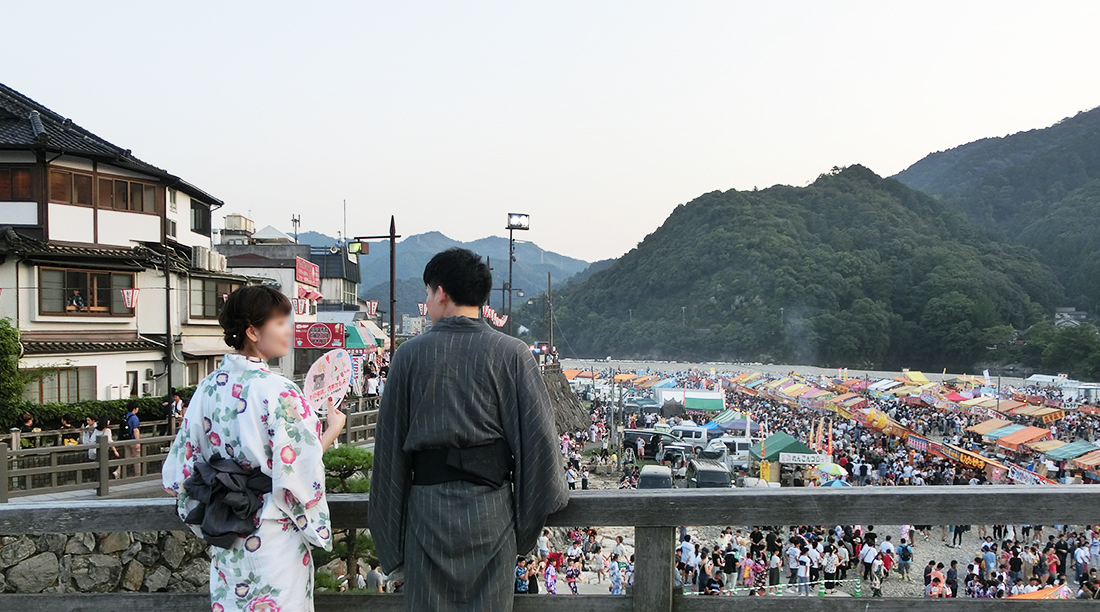 錦帯橋でお祭りを眺める浴衣姿の二人